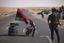 Rebel fighters relax at a checkpoint between Tarhouna and Bani Walid, Libya, Monday, Sept. 5, 2011.