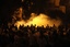 Protesters gather as smoke of tear gas rises nearby during clashes with the Egyptian security forces next to a building housing the Israeli embassy in Cairo, Egypt, early Saturday, Sept. 10, 2011.