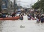 Residents wade through floodwaters as flooding continues for the fourth day Sunday Oct. 2, 2011 at Calumpit township, Bulacan province north of Manila, Philippines.