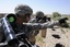 File - Soldiers in Iraq provide security while their platoon attends a local council meeting outside Forward Operating Base Taji, Iraq, July 3, 2010.