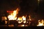 Two army soldiers run after Egyptian Coptic demonstrators by a burning civilian vehicle during clashes with Egyptian Army soldiers following a Copts demonstration in Cairo, Egypt Sunday, Oct. 9, 2011.