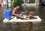 A man rows a floating with his dog on a flooded road in Bangkok, Thailand, Tuesday, Nov. 1, 2011.