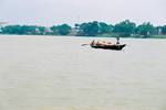 Boat people paddle between Barrackpore and Serampore on the Hooghly river. A photograph shot in 2006