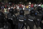 Supporters of the Liberal Independent Party (PLI) shout slogans against Nicaragua's President Daniel Ortega as they protest election results by the Supreme Electoral Council (CSE) outside their voting center where police are lined up one day after general elections in San Juan de la Concepcion, near Managua, Nicaragua, Monday Nov. 7, 2011.