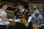 San Antonio City Council Member Christopher "Chip" Haass(center), shakes the hands of West Quarterback Mitch Mustain (left) andEast Quarterback Tim Tebow after they presented him with an honoraryU.S. Army All-American Bowl Jersey. The two quarterbac