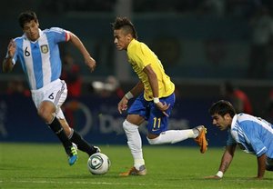 Chased by Argentina's Augusto Fernandez, right, and Argentina's Sebastian Dominguez, left, Brazil's Neymar, center, plays the ball during a friendly soccer match in Cordoba, Argentina, Wednesday, Sept. 14, 2011.