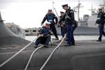 Sailors assigned to the Royal Navy submarine HMS Astute (S119) tend mooring lines as the ship arrives at Naval Station Norfolk.