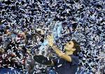 Roger Federer of Switzerland holds up the winners trophy after he defeated Jo-Wilfried Tsonga of France in their singles final tennis match at the ATP World Tour Finals, in the O2 arena in London, Sunday, Nov. 27, 2011.