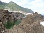 Volcanic rocks, Porto Moniz, Madeira. The phenocrysts or porphyritic minerals are not only larger than those of the ground-mass; as the matrix was still liquid when they formed they were free to take perfect crystalline shapes, without interference by the pressure of adjacent crystals.