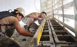 Sapper Benjamin Macpherson of the Australian Army and Steelworker 2nd Class Jessie Majoy level a cinderblock at a GMT engineering civil action project as part of Pacific Partnership.