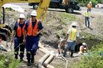 MANGO, Fla. -- Petty Officer 2nd Class Donald Vaughn, left, and Petty Officer 3rd Class Adam Mcinnish, both marine science technicians (MST) from the Coast Guard Sector St. Petersburg Response Division, inspect a broken pipeline that carries jet fuel between Tampa and Orlando that ruptured into Mango Creek July 22, 2011. MSTs are the Coast Guards safety and environmental health experts ashore and they may be assigned to the National Strike Force for oil and hazardous-material response. They cond