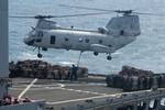 A CH-53E Super Stallion helicopter, assigned to Marine Medium Helicopter Squadron (HMM) 268 Reinforced, transfers cargo from the Military Sealift Command fleet replenishment oiler USNS Tippecanoe (T-AO 199)