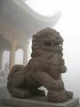 A statue of a Shishi looking over Mount Emei, China