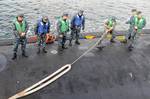 Sailors aboard USS North Carolina receive a line.