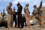 DOURA TALKS - U.S. Air Force Tech. Sgt. Daniel Prosymchak, right, and an interpreter speak to Iraqi civilians during a joint patrol with Iraqi police and Sons of Iraq members for improvised explosive devices in the Doura district of Baghdad, Iraq, Nov. 22, 2008.