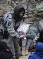 U.S. Navy Petty Officer Second Class (Culinary Specialist) Francine Henry wears a hijab as she distributes cookies she baked to Afghan women