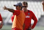 India's cricket team's captain Mahendra Singh Dhoni, front, talks with bowling coach Eric Simons, back, during a training session in preparation for the third cricket Test match against the West Indies in Roseau, Dominica, Monday, July 4 , 2011.