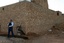 File - Lance Cpl. Nicholas Gilmer, an infantryman with Echo Company, 2nd Battalion, 25th Marine Regiment, Regimental Combat Team 5, and Laith Mohammed Abud, an Iraqi Police officer, pull security at an intersection in Rutbah, Iraq, as their squad leader interviews local residents.