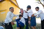 Children climb on Maj. Brad Ward at an elementary school.