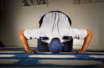 Air Force Muslim Chaplain (Capt.) Shahrior Rahman during prayer, wearing a blue taqiyah/skullcap to blend with his USAF uniform