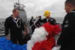 Sailors aboard the guided-missile cruiser USS Gettysburg (CG 64) prepare to hang a lei over the bow as the ship arrives to its homeport of Naval Station Mayport.