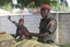 In this Wednesday, Sept. 28, 2011 photo, police officers armed with AK-47 rifles stand guard at sandbagged bunkers along a major road in Maiduguri, Nigeria. The radical sect Boko Haram, which in August 2011 bombed the United Nations headquarters in Nigeria, is the gravest security threat to Africa's most populous nation and is gaining prominence