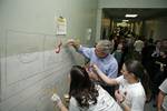 President George W. Bush lends a hand and his best brush strokes at Cardozo Senior High School in Washington, D.C., as volunteers spend Martin Luther King, Jr. Day painting murals of historical figures and local landmarks like the front of 