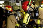 Damage Controlman 2nd Class Jared Olah, a hose team leader assigned to the ship's flying squad, looks through the Navy firefighting thermal imager.