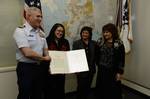 ANCHORAGE, Alaska - Capt. Jason Fosdick, Coast Guard Sector Anchorage commander, presents the Coast Guard Meritorious Public Service Award to Marina Haynes, Machelle Haynes and Mary McDaniel in recognition of their mother, Betty Haynes' role in a 1950 rescue Dec. 15, 2011. Haynes received the award posthumously for her role in saving Christensen Wetche, the only survivor of the fishing vessel Dixie, which sank in the waters near Pelican during a fall storm. U.S. Coast Guard photo by Petty Office