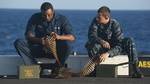 Ship's Serviceman Seaman Lionel Gibson and Yeoman Seaman Brian Johnson count rounds for a .50-caliber machine gun during qualifications on the flight deck of the amphibious transport dock ship USS New Orleans (LPD 18).