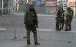 Indian policemen stand on deserted street during a curfew in Srinagar on December 06 ,2011.