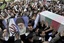 Beside a poster of Iranian supreme leader Ayatollah Ali Khamenei, mourners carry a flag draped coffin of Mostafa Ahmadi Roshan, a chemistry expert and a director of the Natanz uranium enrichment facility in central Iran, who was killed in a brazen daylight assassination when two assailants on a motorcycle attached a magnetic bomb to his car Wednesday, in his funeral ceremony, on Friday, Jan. 13, 2012, in Tehran, Iran.