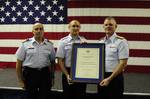 CLEARWATER, Fla. - Coast Guard Petty Officer 2nd Class James Nelson, receives recognition from Rear Admiral Bill Baumgartner, Commander of the 7th Coast Guard District and Capt. John Turner, commanding officer of Air Station Clearwater during an awards ceremony at Air Station Clearwater, Jan. 23, 2012. Lt. George Menze, Lt. George Cottrell, Petty Officer 2nd Class Sara Faulkner and Nelson made up the four person Air Station Clearwater MH-60 Jayhawk helicopter crew who battled harsh weather condi