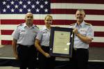 CLEARWATER, Fla. - Coast Guard Petty Officer 2nd Class Sara Faulkner, receives recognition from Rear Admiral Bill Baumgartner, Commander of the 7th Coast Guard District and Capt. John Turner, commanding officer of Air Station Clearwater during an awards ceremony at Air Station Clearwater, Jan. 23, 2010. Lt. George Menze, Lt. George Cottrell, Petty Officer 2nd Class James Nelson, and Faulkner made up the four person Air Station Clearwater MH-60 Jayhawk helicopter crew who battled harsh weather co