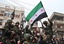 Syrian army defectors, celebrate and wave the Syrian revolution flag shortly after they defected and join the anti-Syrian regime protesters at Khalidiya area in Homs province, central Syria, on Thursday, Jan. 26, 2012.