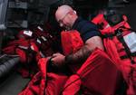 Boatswain's Mate 2nd Class Robert D. Beaver sorts life preservers.