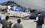 Police officers stand next a group of bodies outside the 