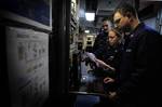 Sailors configure the global broadcast system in the main communications space.