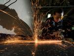 Hull Maintenance Technician 3rd Class Jesseca Crosby grinds down an unused deck fitting while installing new equipment mounts aboard the Nimitz-class aircraft carrier USS Carl Vinson (CVN 70).