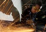 Hull Maintenance Technician 3rd Class Jesseca Crosby grinds down an unused deck fitting while installing new equipment mounts aboard the Nimitz-class aircraft carrier USS Carl Vinson (CVN 70).