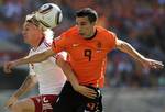 Denmark's Simon Kjaer, left, competes for the ball with Netherlands' Robin van Persie, right, during the World Cup group E soccer match between the Netherlands and Denmark at Soccer City in Johannesburg, South Africa, Monday, June 14, 2010.