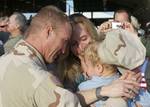 TAMPA, Fla. - A Clearwater, Fla., based Port Security Unit 307 member embraces his family after returning home from an extended deployment to the Middle East, Jan. 23, 2012. While deployed, PSU 307 members provided harbor defense and security to ports, seaward approaches, and waterways within U.S. Central Command's area of responsibility and ensuring the free flow of personnel, equipment and commerce in the region. U.S. Coast Guard photo by Petty Officer 2nd Class Michael Anderson. (1503854) ( P