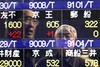 Businessmen are reflected in the electric stock board of a securities firm in Tokyo Monday, March 1, 2010. Asian stock markets advanced Monday, with Hong Kong's index up nearly 2 percent, after China said manufacturing continued to grow last month albeit at a slower pace. Nikkei 225 stock average ended at 10,172.06, up 46.03 points. (AP Photo/Koji Sasahara)