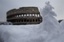 Snow surrounds the ancient Colosseum, in Rome Saturday, Feb. 4, 2012. A rare snowfall blanketed Rome forcing the closure of the Colosseum over fears tourists would slip on the icy ruins, and leaving buses struggling to climb the city's slushy hills.