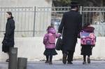 In this Tuesday, Jan. 3, 2012 photo, an Ultra Orthodox man takes his daughters to school in the Mea Shearim Ultra Orthodox Jewish neighborhood in Jerusalem.