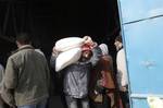 Palestinians receive their monthly food aid at a UN distribution center in the Shati refugee camp,January 17, 2012, in Gaza City. The UN Agency for Palestinian Refugees (UNRWA) in Gaza launched an appeal for emergency funds to the Palestinian territories of $ 300 million (235 million), The Deputy Chief Commissioner Margo Ellis at the third anniversary of the end of the devastating Israeli operation 