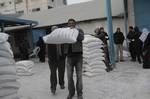 Palestinians receive their monthly food aid at a UN distribution center in the Shati refugee camp,January 17, 2012, in Gaza City. The UN Agency for Palestinian Refugees (UNRWA) in Gaza launched an appeal for emergency funds to the Palestinian territories of $ 300 million (235 million), The Deputy Chief Commissioner Margo Ellis at the third anniversary of the end of the devastating Israeli operation 