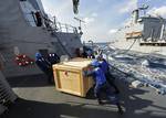 Sailors aboard the Arleigh Burke-class guided-missile destroyer USS Dewey (DDG 105) remove a cargo box from the pallet landing zone during an underway replenishment.