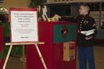 Lance Cpl. Nicholas Castro drops a toy into the collection box for the U.S. Marine Corps Reserve Toys for Tots Program.