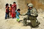 U.S. Air Force Senior Airman Sarah Baker, rifleman, greets children during a security halt in Qalat City, Afghanistan, Aug. 10, 2011. Airman Baker is a member of Provincial Reconstruction Team Zabul's security force and is a services Airman deployed from Malmstrom Air Force Base, Montana. PRT Zabul is comprised of Air Force, Army, Department of State, U.S. Agency for International Development, U.S. Department of Agriculture, and U.S. Army Corps of Engineers personnel who work with the government